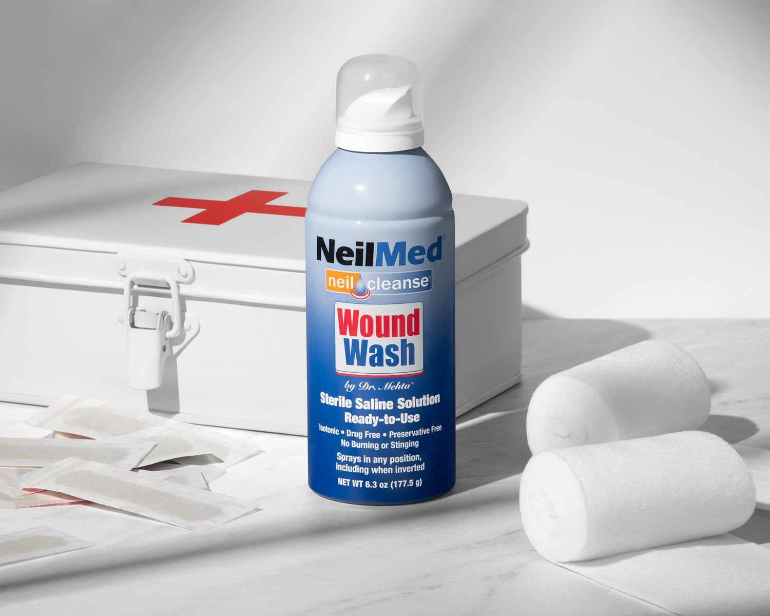 NeilMed Wound Wash bottle on a white surface with a first aid kit in the background
