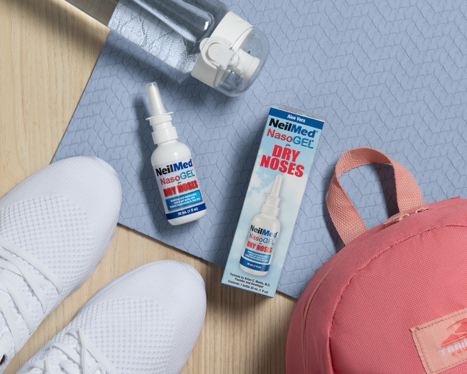 NasoGel spray pump on teh floor next to white shoes, a water bottle, and next to a pink backpack