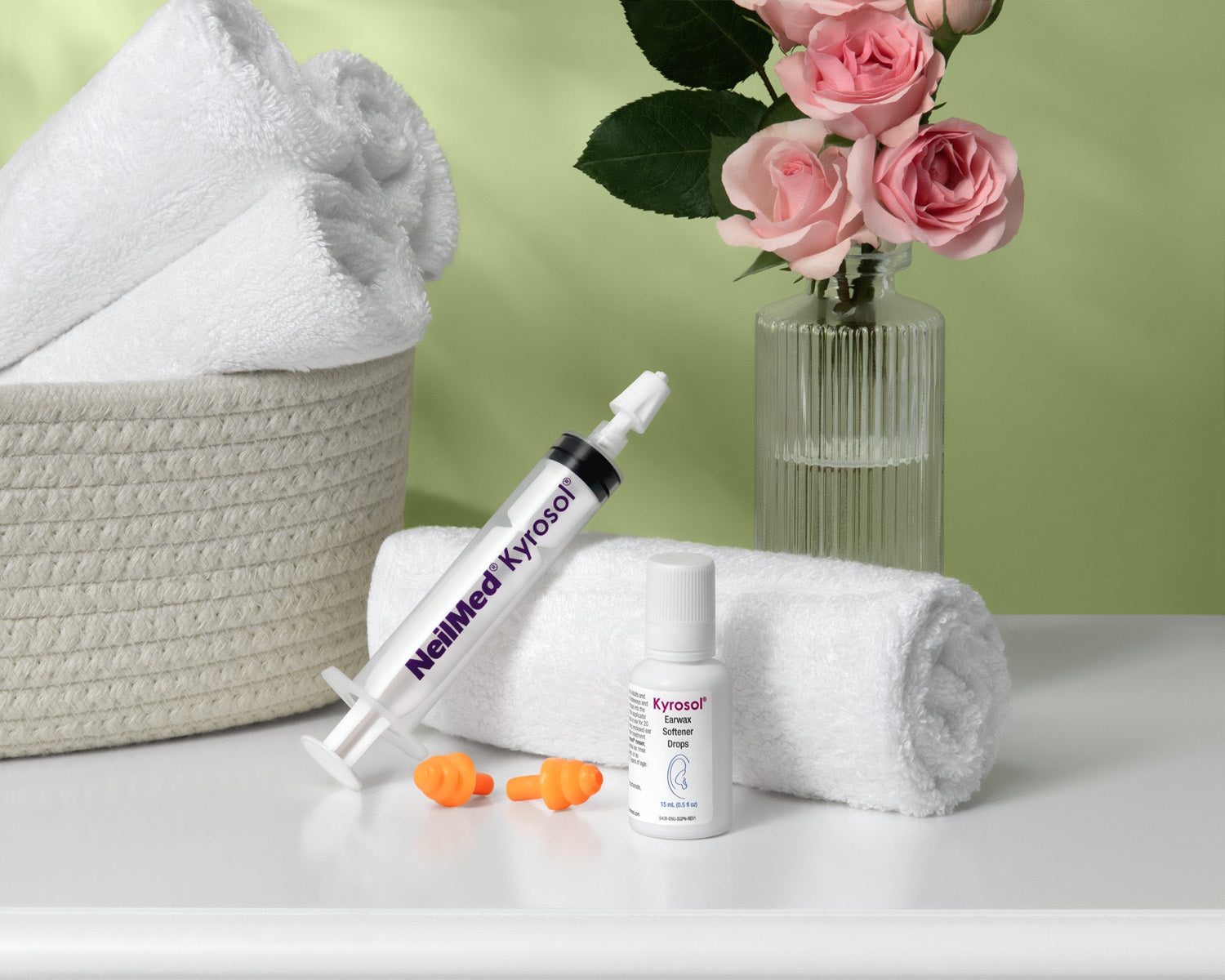 Neulmed Kyrosol products with towels and flowers on a light green background